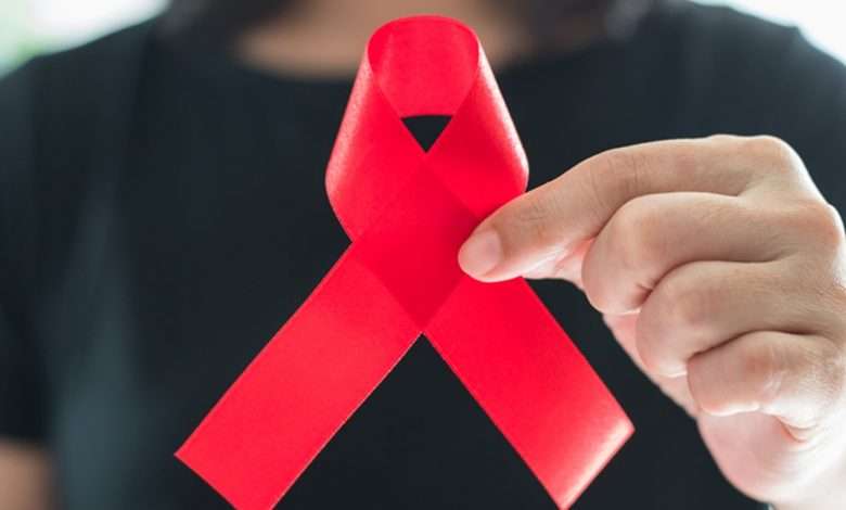 Aids red ribbon on woman's hand support for World aids day and national HIV/AIDS and aging awareness month concept ویروس HIV