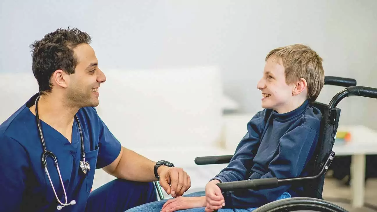 5942 boy wheelchair talking doctor 1296x728 header - درمان بیماری SMA ؛ وقتی ژن درمانی باعث لبخند یک کودک می شود